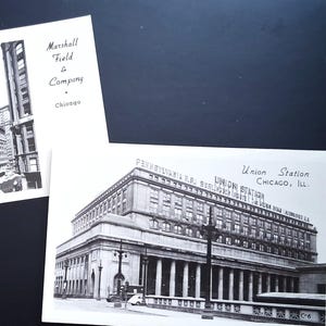 Op de afbeelding: Twee zwart-wit ansichtkaarten met Chicago-architectuur. Eén toont Marshall Field & Company, de andere Union Station. Beide kaarten zijn rechthoekig en voorzien van tekst.