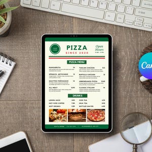 May include: A tablet displays a pizza menu with the text "PIZZA SINCE 2020". The menu includes pizza options, drinks, and open hours. The tablet is on a wooden surface, with a keyboard, notepad, pen, and coffee cup nearby.