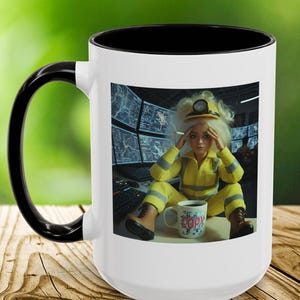 May include: White ceramic mug with a black interior and handle. The mug features a colorful image of a doll in a yellow jumpsuit, a hard hat, and a coffee mug that says "COPY". The background shows computer screens.