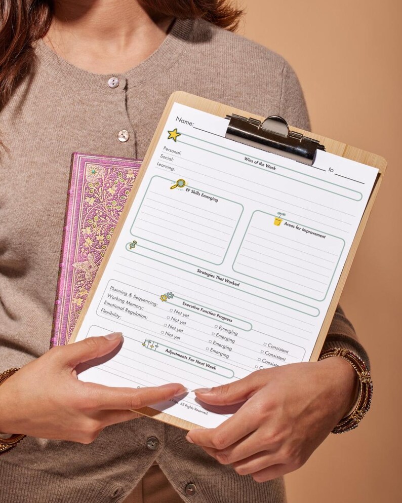 Pu&ograve; includere: Un portablocco in legno con un foglio di lavoro stampato, tenuto con un diario viola. Il foglio di lavoro include sezioni per obiettivi personali, sociali e di apprendimento, con aree di miglioramento e progresso delle funzioni esecutive.