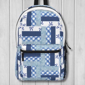 Puede incluir: Mochila azul y blanca con diseño de patchwork. El diseño incorpora cuadros de vichy y secciones azules lisas, con pequeños motivos de lazo. Tiene un bolsillo frontal con cremallera, un bolsillo lateral de malla y un asa superior.