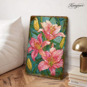 May include: A rectangular metal sign featuring a floral design with pink lilies and yellow buds against a teal background. The sign has a distressed, vintage look with the word "Kanyawe" in the upper right corner.