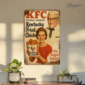 May include: Vintage KFC metal sign featuring Colonel Sanders and a woman holding a bucket of fried chicken. The sign has the KFC logo and the phrase "It's finger lickin' good!" in a retro style.