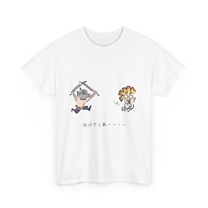 Pode incluir: Camiseta branca com uma ilustração de desenho animado de dois personagens de anime. Um personagem empunha espadas e o outro parece assustado. Texto japonês abaixo.