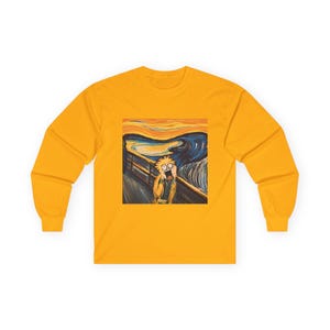 May include: Mustard yellow long-sleeved top featuring a parody of Edvard Munch's "The Scream" painting. The artwork depicts a cartoon character with a shocked expression against a swirling sky and bridge background.