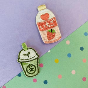 Peut inclure: Écussons brodés représentant une bouteille de lait à la fraise et une boisson au thé vert. L'écusson au lait de fraise comporte du texte japonais et une illustration de fraise. L'écusson au thé vert comporte du texte japonais et une illustration de thé vert.
