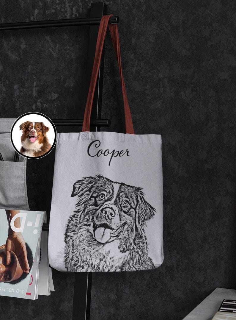 Puede incluir: Una bolsa de lona blanca con asas marrones. La bolsa presenta una ilustraci&oacute;n en blanco y negro de un perro con el nombre "Cooper" impreso en cursiva negra sobre el perro.