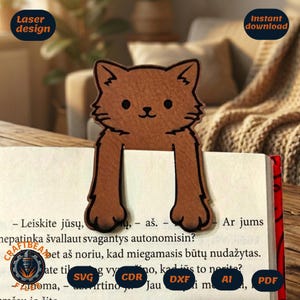 May include: A brown wooden cat-shaped bookmark with black engraved outlines for the face and paws, positioned over an open book page. The design features a cat head with two long front paws extending downward, resting on the printed text of the book.