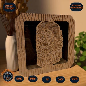 Può includere: Una scatola ombra in legno con un design a teschio di zucchero tagliato al laser e la scritta "TATTOO FUNDS". La cornice ha un motivo a venature del legno. Sono visibili anche le parole "Laser design" e "Instant download".