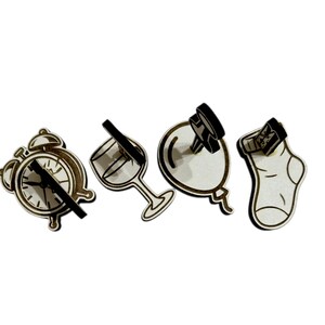 May include: A collection of four wooden cutouts: an alarm clock, a wine glass, a balloon, and a sock. Each cutout has a black accent, creating a contrast against the light wood. The clock hands are black, and the wine glass has a black stem.