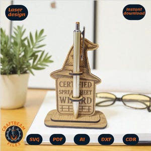 May include: A wooden pen holder in the shape of a wizard's hat, holding a pen. The holder has the text "CERTIFIED SPREADSHEET WIZARD". The design is laser cut. The pen holder is on a desk with glasses and a plant.