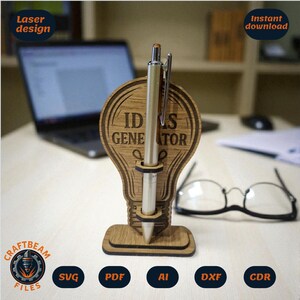 May include: A wooden pen holder in the shape of a lightbulb with the words "IDEAS GENERATOR" engraved on it. A silver pen is inserted in the holder. The words "Laser design" and "Instant download" are also visible.