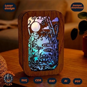 Könnte beinhalten: Eine rechteckige Lichtbox aus Holz mit einem lasergeschnittenen Motiv eines Teichs mit Koi-Fischen, Lotusblumen und Bambusstangen. Das Innere ist mit einem Farbverlauf aus Blau, Violett und Weiß beleuchtet, was einen Schichteffekt erzeugt.