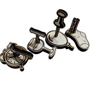 May include: Wooden cutouts of various objects, including an alarm clock with a bird, a wine glass with a corkscrew, a balloon with a push pin, and a sock with a clothespin. The objects are light brown with black accents.