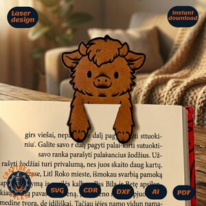 Puede incluir: Un marcapáginas de madera marrón con forma de vaca Highland de dibujos animados con pelaje desgreñado, cuernos pequeños y dos patas delanteras que descansan sobre el borde superior de un libro abierto. El diseño tiene contornos grabados.