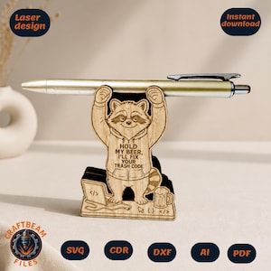 May include: Wooden pen holder featuring a raccoon design. The raccoon is holding up a pen and wearing a hoodie with the text "HOLD MY BEER, I'LL FIX YOUR TRASH CODE." The base includes a laptop and a beer mug. Laser design and instant download.
