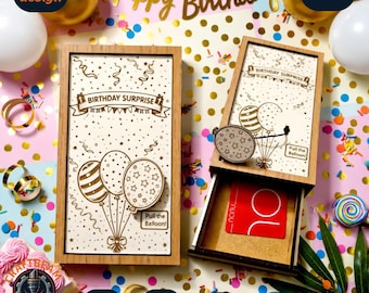 May include: Two rectangular wooden gift boxes featuring laser-engraved birthday designs. The boxes display balloons, confetti, and the text "BIRTHDAY SURPRISE" and "Pull the Balloon!". One box is closed, while the other is partially open.