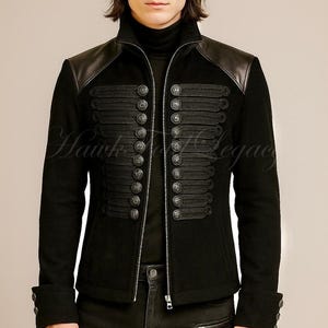 May include: Black jacket with leather shoulder accents, multiple decorative buttons, and a high collar. The jacket features a zipper closure and decorative rope detailing. The text "Hawk Legacy" is visible on the jacket. The jacket is part of a clothing collection.