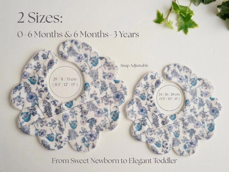 May include: Two floral baby bibs in different sizes, featuring a white background with blue and purple flower patterns. The bibs are snap adjustable and measure 9.5 to 13 inches in width. Text on the image reads "From Sweet Newborn to Elegant Toddler."