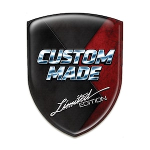 Op de afbeelding: Een schildvormig embleem met een glanzende afwerking. De linkerbovenhoek is zwart met een textuurpatroon en de rechterbovenhoek is rood met een distressed textuur. De woorden "CUSTOM MADE" zijn zilverkleurig en "Limited Edition" is cursief geschreven.