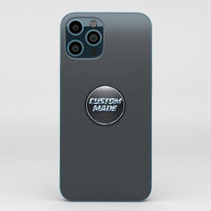 Puede incluir: Un smartphone gris oscuro con un borde azul y una c&aacute;mara de triple lente. Un soporte circular y met&aacute;lico con las palabras "CUSTOM MADE" est&aacute; adherido a la parte posterior del tel&eacute;fono.