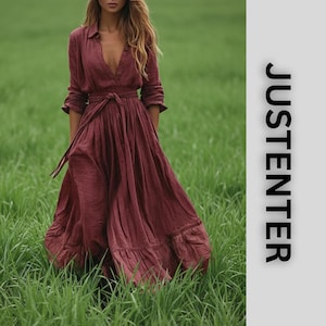 May include: A long, burgundy dress with long sleeves and a button-down front. The dress has a tie-waist and a flowing skirt. The word "JUSTENTER" is printed vertically on the right side of the image. The model is standing in a field of green grass.