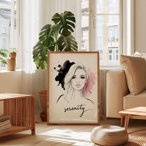 Peut inclure: Une affiche encadrée représentant un portrait à l'aquarelle d'une femme aux longs cheveux blonds. L'œuvre comprend des éclaboussures de peinture noire et rose et le mot "serenity" en écriture cursive. Le cadre est en bois.