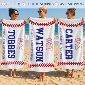 May include: Three white rectangular beach towels featuring a red baseball stitch pattern at the top and bottom. Each towel displays a blue surname, a team name, the text 2026 SEASON, and a red jersey number: TORRES #99, WATSON #27, and CARTER #12.