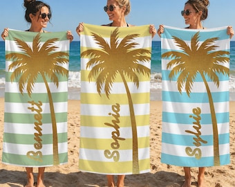 May include: Three rectangular beach towels featuring horizontal stripes and a large gold palm tree graphic. Each towel displays a custom name in gold script: Bennett on a green striped towel, Sophia on a yellow one, and Sylvie on a blue one.