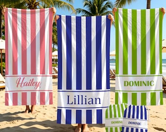 May include: Three rectangular beach towels featuring vertical stripes in pink, blue, and lime green, each with a solid horizontal band displaying the names Hailey, Lillian, and Dominic. Two matching drawstring bags are also visible on the sand.
