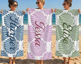 May include: Three rectangular beach towels featuring a repeating seashell pattern. The left towel is blue with the name Harper, the center is purple with the name Tessa, and the right is green with the name Elise printed in script.