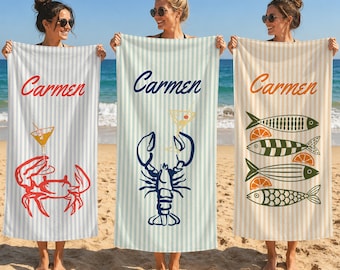 May include: Three rectangular beach towels featuring vertical stripes and the name Carmen in script. The left towel has a red crab and cocktail, the center has a blue lobster and cocktail, and the right has four fish and orange slices.