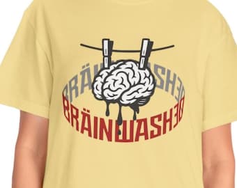 Könnte beinhalten: Hellgelbes T-Shirt mit einer Grafik eines Gehirns, das an einer Wäscheleine mit Wäscheklammern hängt. Das Wort "BRAINWASHED" ist in einem Kreis um das Gehirn in Rot und Grau gedruckt.