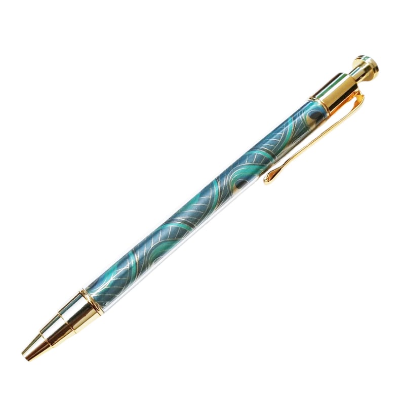 May include: A decorative pen with a teal and gold peacock feather design. The pen has a gold clip and accents. The pen is a writing instrument.