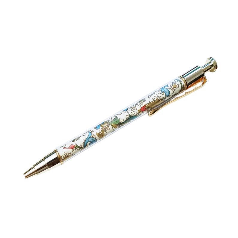 May include: A white pen with a floral design in blue, green, and red. The pen has a gold clip and silver accents on the tip and top. The pen is a writing instrument.