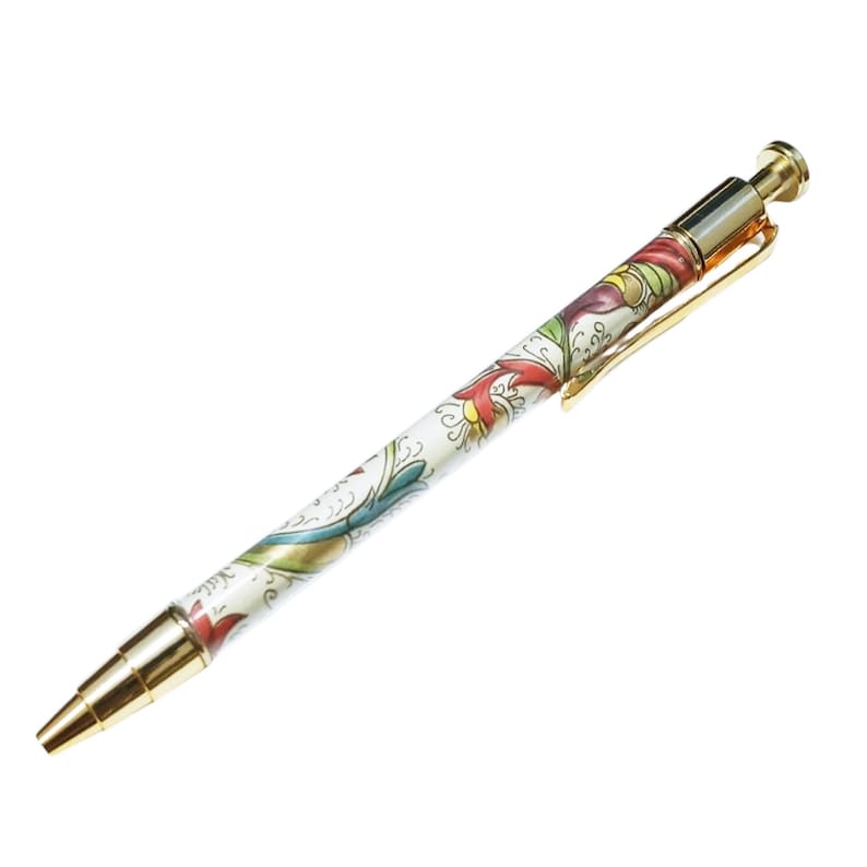 May include: A decorative pen with a white barrel featuring a colorful floral design in red, yellow, and green. The pen has gold-colored metal accents, including the tip, clip, and push button.
