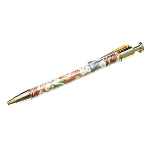 May include: A decorative ballpoint pen with a white barrel featuring a colorful floral design in red, orange, green, and blue. The pen has gold-colored metal accents on the tip, clip, and end. The pen is approximately 5.5 inches long.