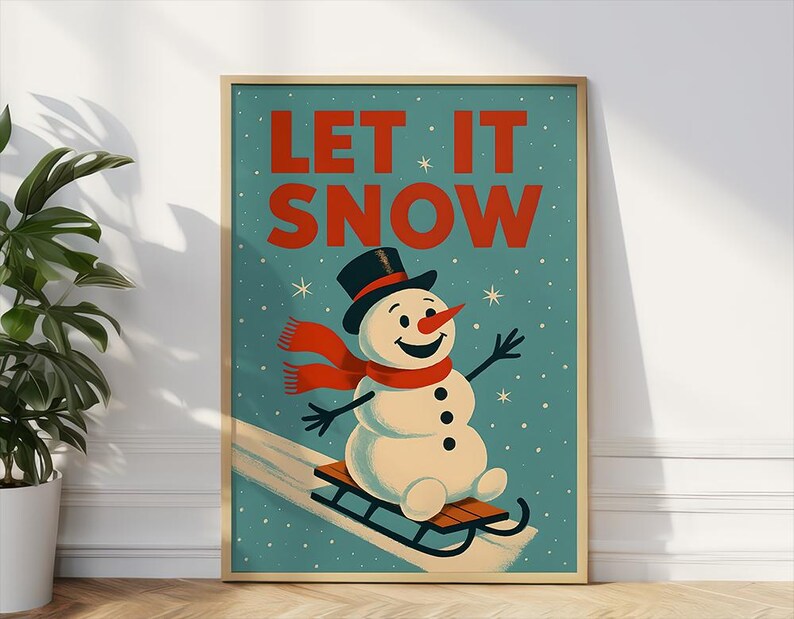 May include: A framed winter-themed art print showing a snowman on a sled. The snowman has a black top hat, red scarf, and carrot nose. The words "LET IT SNOW" are in red against a teal background.