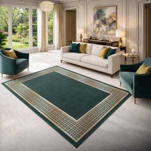 May include: A rectangular area rug featuring a deep forest green center field surrounded by a wide, ornate border with a repeating gold geometric lattice pattern. The rug is positioned on a light-colored floor in a room with teal armchairs.