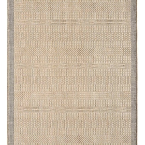 Op de afbeelding: Rechthoekig beige tapijt met een geweven textuur en een grijze rand. Het oppervlak van het tapijt heeft een herhalend patroon van kleine vierkanten en lijnen, waardoor een getextureerd uiterlijk ontstaat. De rand is effen grijs.