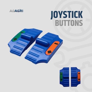 Puede incluir: Dos botones de joystick azules con detalles verdes y naranjas. Los botones tienen forma rectangular con una manija elevada y el texto "JOYSTICK BUTTONS". El logotipo de ADAGRI está en la esquina superior izquierda.