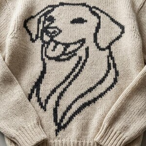 Può includere: Maglione beige a maglia con un motivo a forma di faccia di cane sorridente nera. Il maglione ha un girocollo e polsini e orlo a coste. Un capo comodo per l'uso quotidiano.