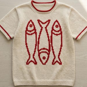 May include: A short-sleeved, beige knit shirt with a red trim around the neckline and sleeves. The front of the shirt features a red graphic of three fish. The fish are stylized and arranged vertically.