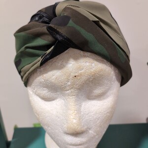 May include: A camouflage patterned headband with a black ribbon tied in a knot on top.