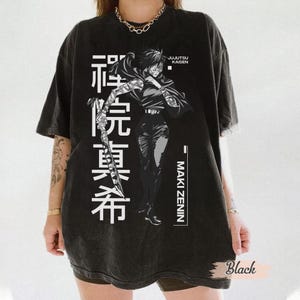 May include: Black graphic t-shirt featuring a detailed illustration of a character from Jujutsu Kaisen, Maki Zenin, with Japanese text. The design is in white, set against a black background. The shirt has a vintage, washed look.