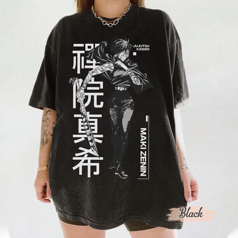 May include: Black graphic t-shirt featuring a detailed illustration of a character from Jujutsu Kaisen, Maki Zenin, with Japanese text. The design is in white, set against a black background. The shirt has a vintage, washed look.