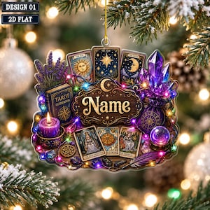 May include: A flat, hanging ornament featuring a central wooden sign with the text Name, surrounded by tarot cards, a purple candle, a crystal cluster, a tarot guidebook, and a crystal ball, all illuminated by colorful string lights.
