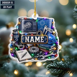 May include: A flat, decorative ornament featuring a mechanical engineering theme with a computer screen showing a technical drawing, a blue hard hat, a stack of books, a notebook, a wrench, gears, and a caliper, with the text NAME in the center.