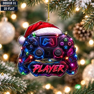 May include: A flat, 2D hanging ornament shaped like a video game controller, featuring a red Santa hat on top, colorful string lights wrapped around the body, and the word PLAYER in bold red text at the bottom, all set against a dark background.