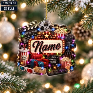 May include: A flat, cinema-themed Christmas ornament featuring a central marquee sign with the word Name, a film reel, a clapperboard, a red armchair, a movie night drink cup, 3D glasses, a popcorn bucket, a film camera, and a remote control.